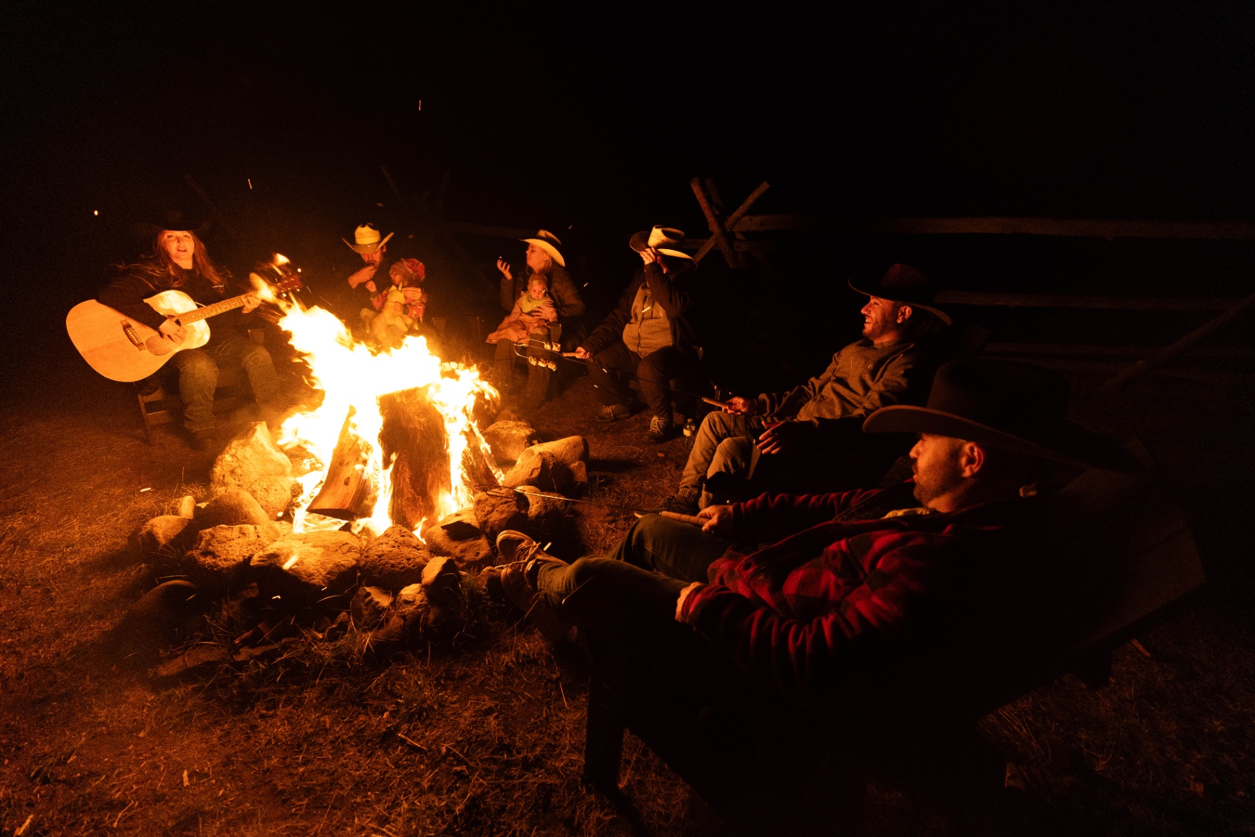 Guests gathered around the campfire at Big Bar Guest Ranch