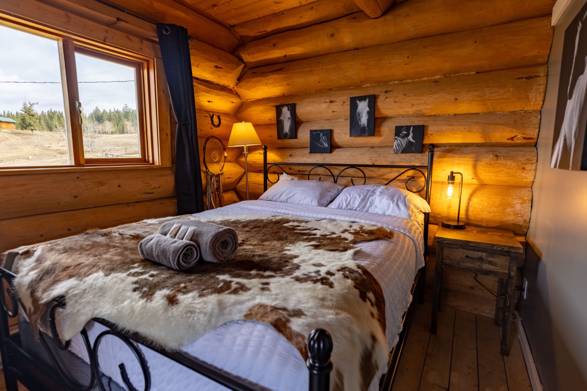 Cozy log cabin bedroom with queen bed and warm lighting