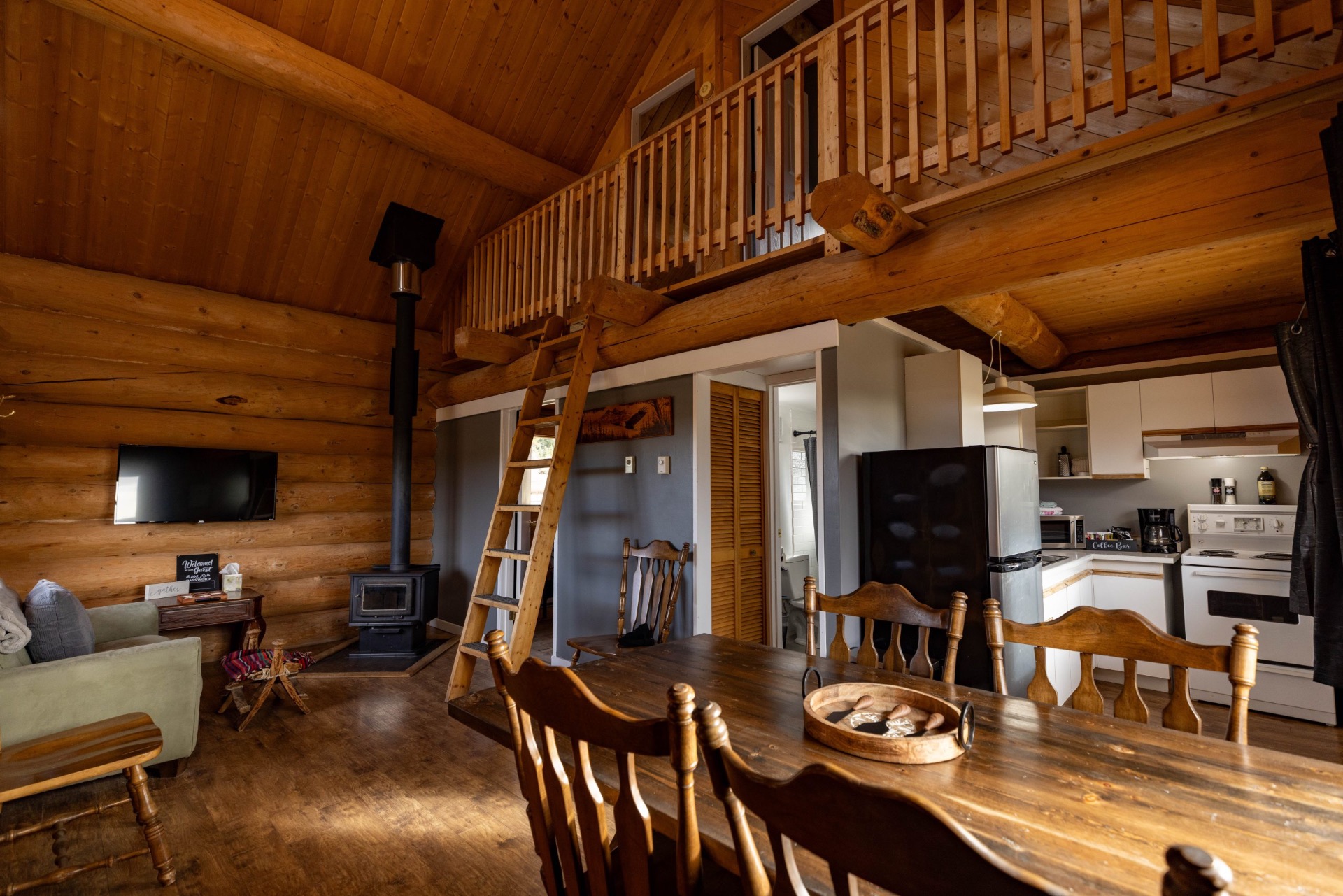 Open living, dining, and kitchen area with loft inside Cabin 1