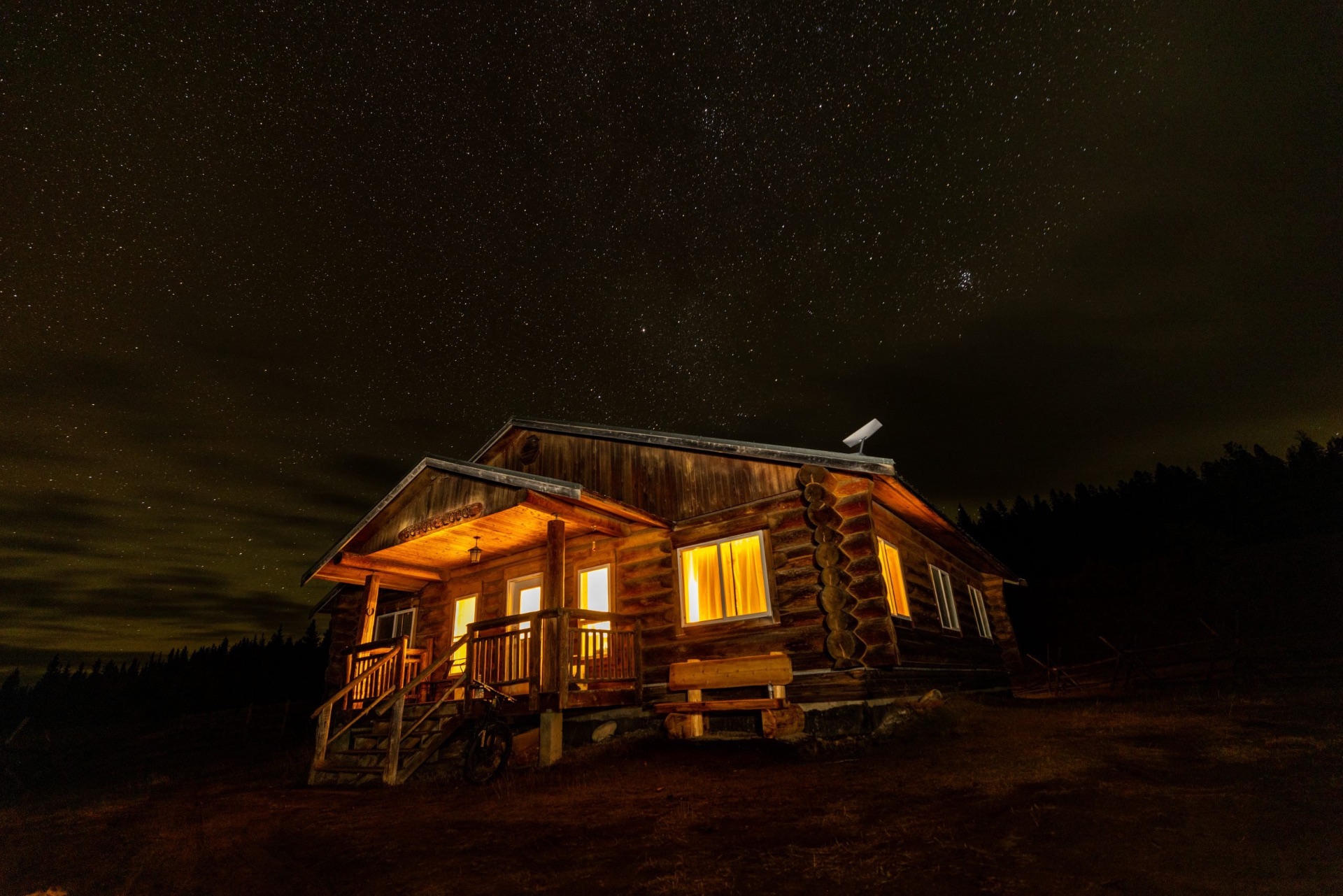 Ranch buildings glowing under a night sky