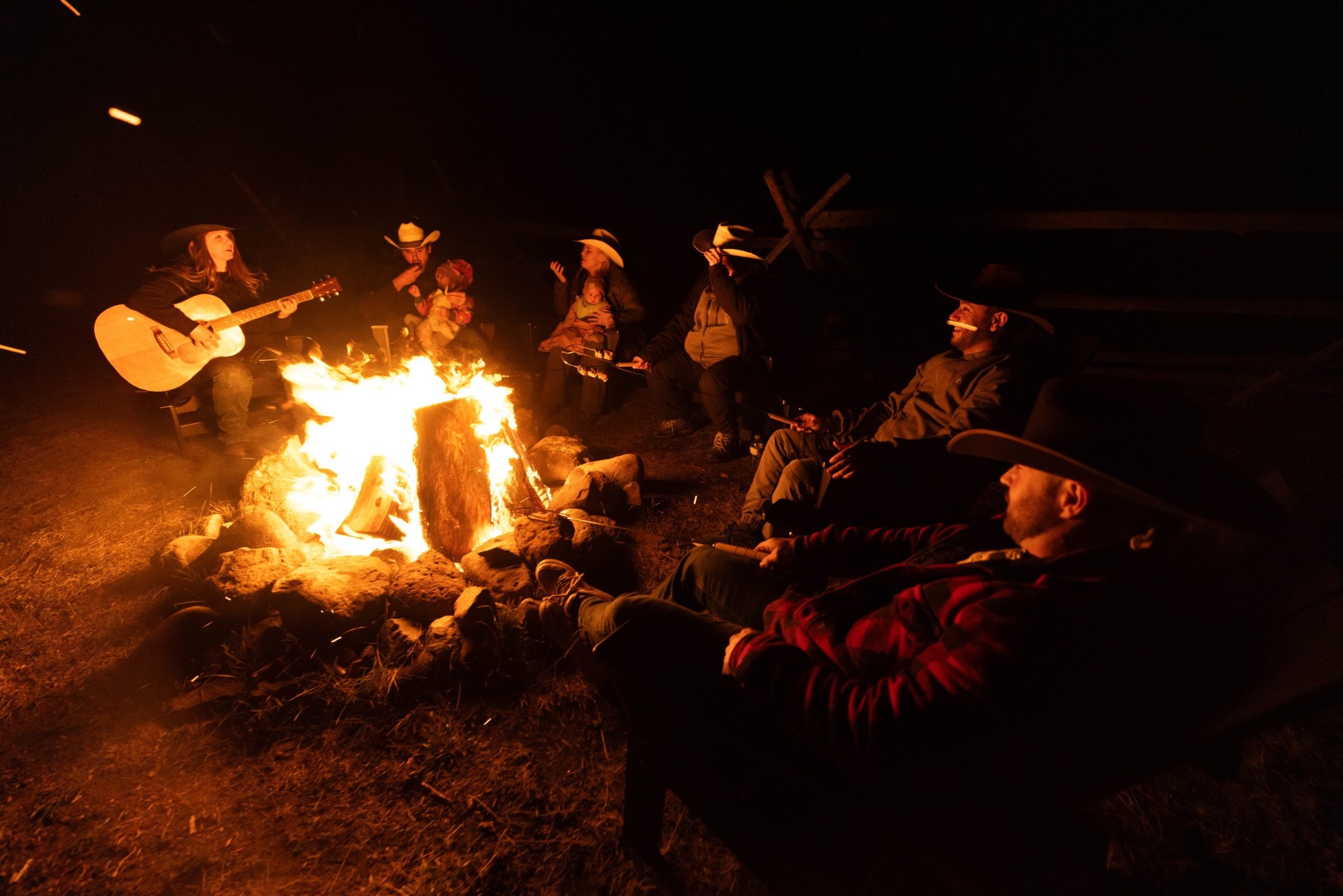 Group gathered around a campfire beneath a starry sky