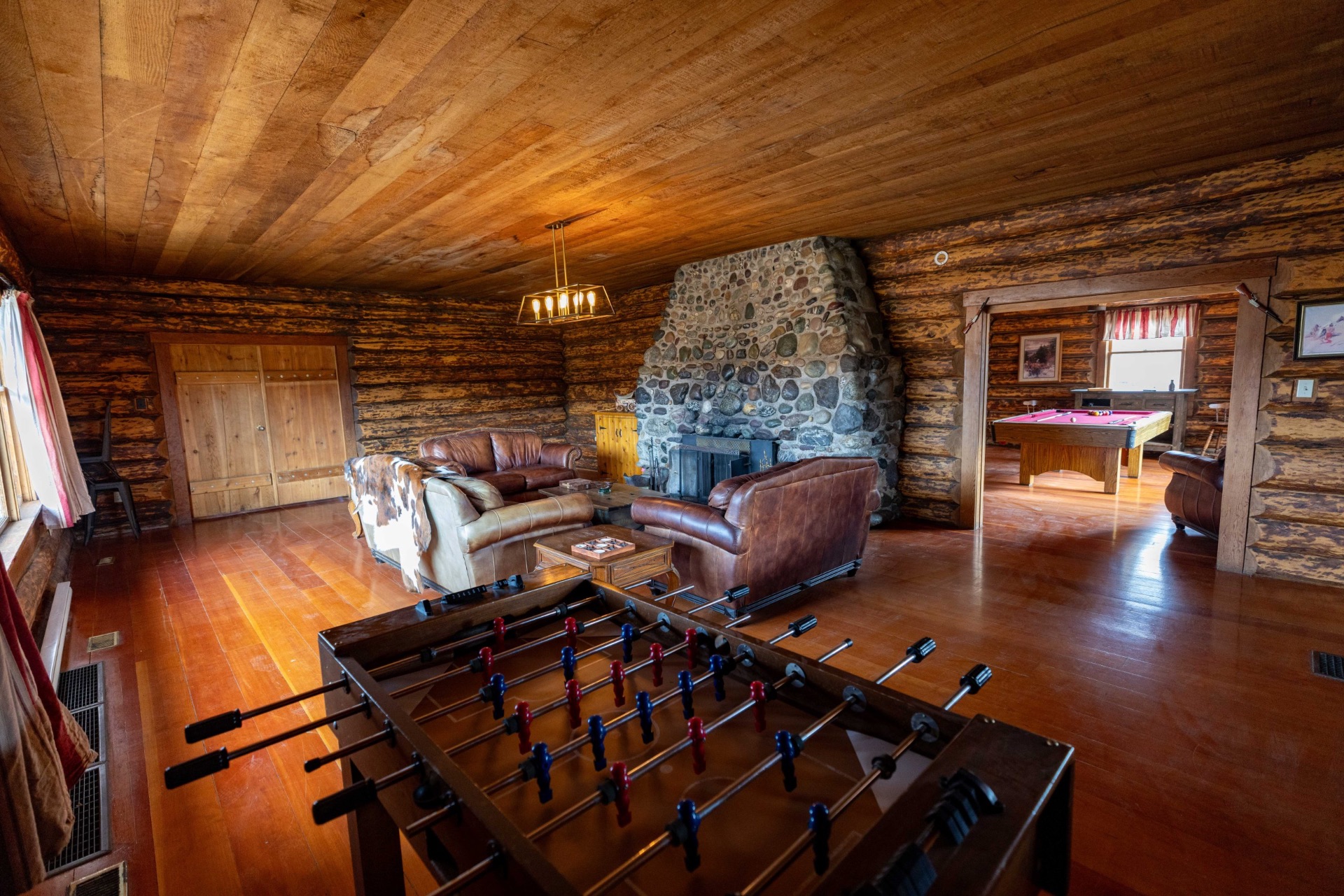 Harrison House interior with stone fireplace, pool table, and foosball