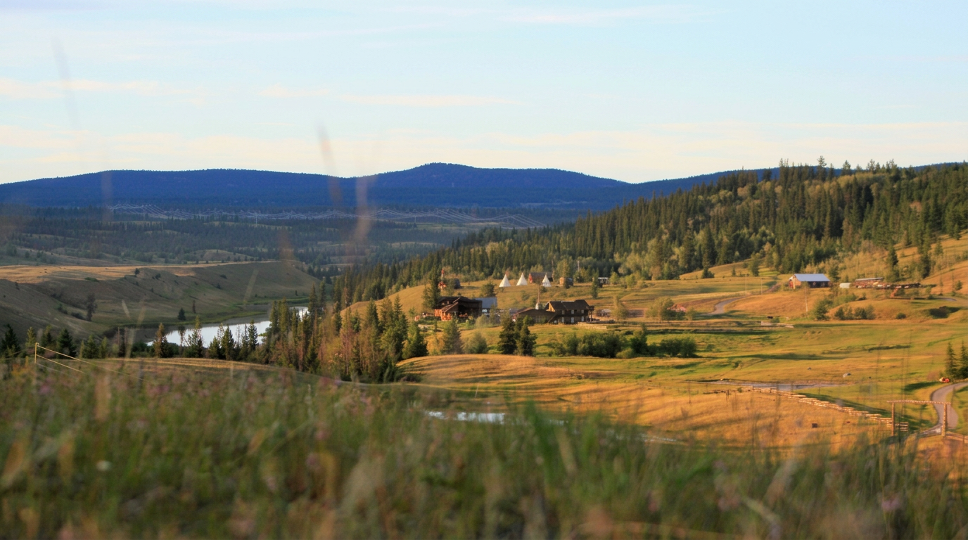 Aerial view of a river winding through a British Columbia mountain valley at sunset